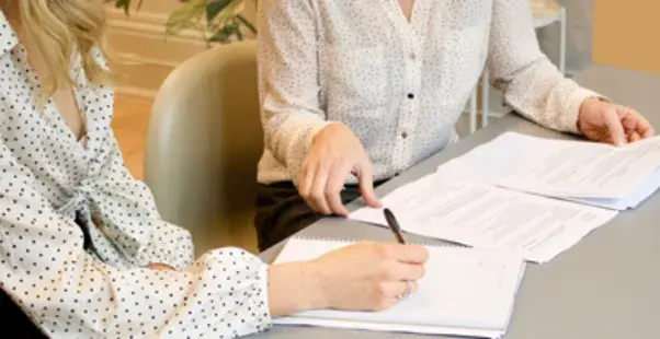 office workers handling paperwork on a desk